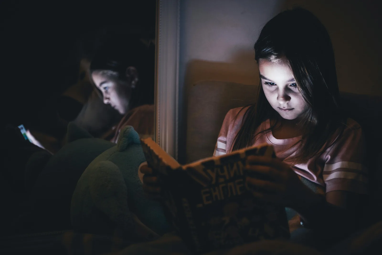 Person wearing glasses while working at a computer in a softly lit room